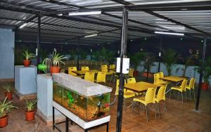 a patio with a fish tank and tables and chairs at MEGH RESIDENCY in Navi Mumbai