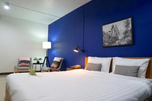 een slaapkamer met een groot bed met een blauwe muur bij The View Residence in Bangkok