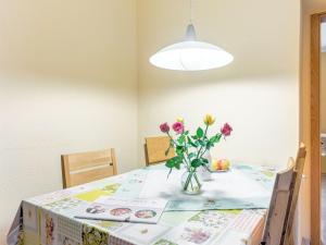 una mesa de comedor con un jarrón de flores. en Flat near the ski resort in Rauschenbach, en Neuhausen