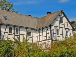 a white and black house with a gray roof at Apartment in Winterberg with garden in Winterberg