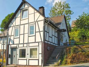 a large white and black house with stairs at Apartment in Winterberg with garden in Winterberg