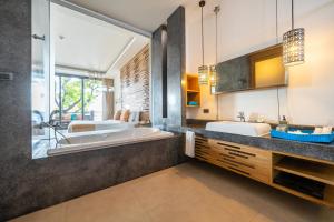 un bagno con due lavandini, vasca e lavandino di Sai Kaew Beach Resort a Ko Samed