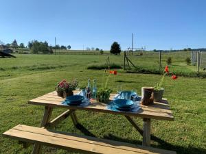- une table de pique-nique avec des assiettes et de la vaisselle dans un champ dans l'établissement Vent_du_Nord, à Tramelan