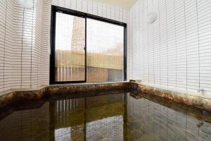 a room with a window and a pool of water at Kanoe in Iiyama