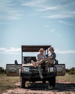 zwei Leute sitzen hinten im Jeep in der Unterkunft Honeyguide Tented Safari Camp - Khoka Moya in Manyeleti Game Reserve