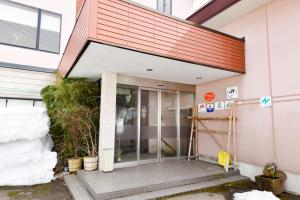 una entrada a un edificio con una puerta de cristal en Kanoe, en Iiyama