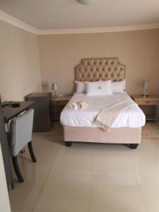a bedroom with a large bed and a desk at Mminanoko Eco Guesthouse in Mamphokgo +31 photos