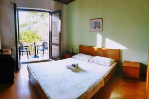 a bedroom with a bed and a balcony with a table at Apartments Asija in Brela