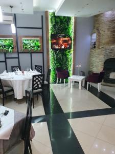 comedor con mesas y sillas y chimenea en Sunny Hill Garden, en Stara Pazova