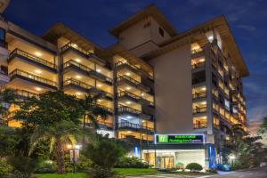 ein Mehrfamilienhaus in der Nacht mit eingeschaltetem Licht in der Unterkunft Holiday Inn Express Haikou West Coast, an IHG Hotel in Haikou