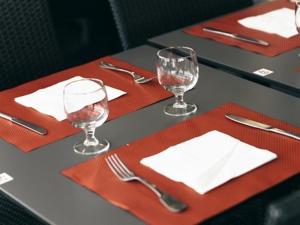 a table with red napkins and wine glasses on it at Hôtel Restaurant Le Lion d'Or in Meximieux