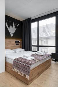 a bedroom with a bed and a large window at Baza Smart Hotel in Bukovel