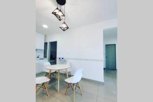 @Sentrovue Homestay AFIQ near UiTM/Hosp PuncakAlam في كوالا سيلانجور: مطبخ مع طاولة وكراسي في غرفة