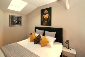 um quarto com uma cama com almofadas amarelas em Villa Etoile Cannes em Cannes