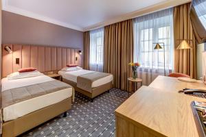 a hotel room with two beds and a window at Arbat Nord Hotel in Saint Petersburg