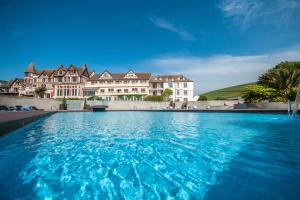 a large swimming pool in front of a large building at The Woolacombe Bay Hotel in Woolacombe