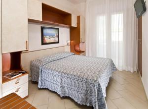 a small bedroom with a bed and a window at Hotel Tura in Bellaria-Igea Marina