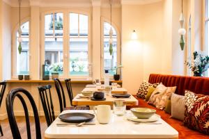 a dining room with tables and chairs and windows at Bonsoir Madame in Paris