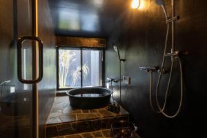 a bathroom with a tub and a shower with a window at Yoinotake Machiya House in Kyoto