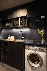 a kitchen with a washing machine and a microwave at Yoinotake Machiya House in Kyoto