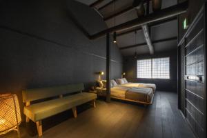 a bedroom with a bed and a bench and a window at Yoinotake Machiya House in Kyoto