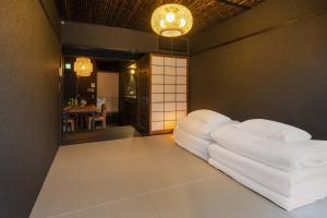 a living room with a white couch sitting on the floor at Yoinotake Machiya House in Kyoto