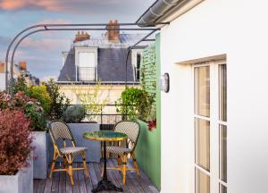 a patio with two chairs and a table on a balcony at Bonsoir Madame in Paris