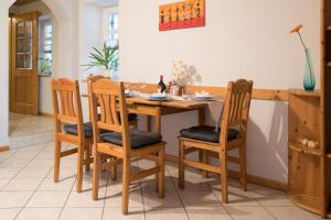 una sala da pranzo con tavolo e sedie in legno di Ferienwohnung in Bad Staffelstein OT Grundfeld a Bad Staffelstein