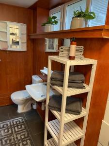 a bathroom with a toilet and a shelf with towels at Rymlig lägnhet med 2 sovrum in Oxie