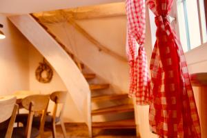 un escalier avec une cravate rouge et blanche à damier sur un mur dans l'établissement Zum Alten Backhaus, à Burg