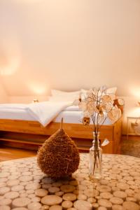 1 dormitorio con 1 cama y 1 mesa con flores en Zum Alten Backhaus en Burg (Spreewald)