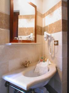 bagno con lavandino e specchio di Albergo Il Giglio a Montalcino