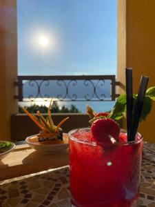 ein rotes Getränk im Glas auf dem Tisch in der Unterkunft Camin Hotel Luino in Luino