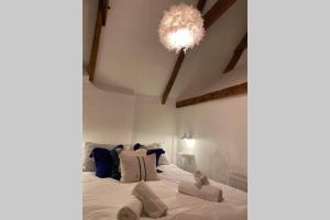 a bedroom with a large white bed with a chandelier at The Nest - St Ives in St Ives