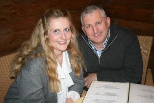 een man en een vrouw aan een tafel met een boek bij Zimmervermietung Babsy in Zell am See