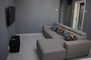 a living room with a couch and a television at Blue Breeze in Luanda