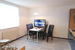 a room with a table with chairs and a computer at Dimai House No 17 Dornbirn Zentrum in Dornbirn