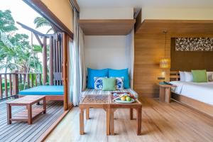 a room with a bed and a table and a bed at Ao Prao Resort in Ko Samed