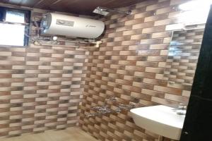 MahādKuber's Residency的浴室配有卫生间、水槽和墙壁。