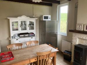a kitchen with a wooden table and a refrigerator at Authentic Dikehouse at sea in Walsoorden