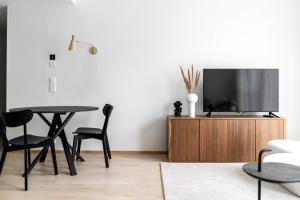 a living room with a tv and a table and chairs at Roost Hämeenkatu in Tampella