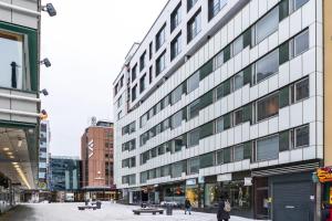a tall white building with people walking in front of it at Roost Hämeenkatu in Tampella