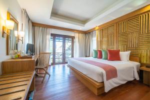 a bedroom with a large bed and a desk and a desk at Ao Prao Resort in Ko Samed