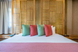 a bed with colorful pillows on top of it at Ao Prao Resort in Ko Samed