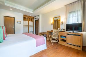 a bedroom with a bed and a desk and a television at Ao Prao Resort in Ko Samed