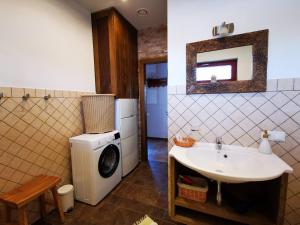 a bathroom with a washing machine and a sink at Jaunstūrīši in Ādaži