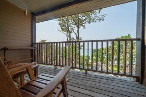 a screened in porch with a bench and a view at Ao Prao Resort in Ko Samed