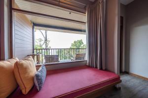 a room with a large window with a red bench at Ao Prao Resort in Ko Samed