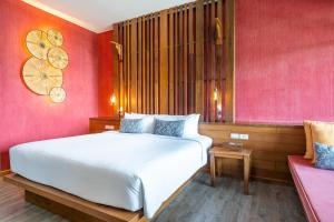 a bedroom with a white bed and a pink wall at Ao Prao Resort in Ko Samed