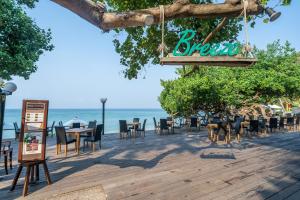 a restaurant on the beach with tables and chairs at Ao Prao Resort in Ko Samed